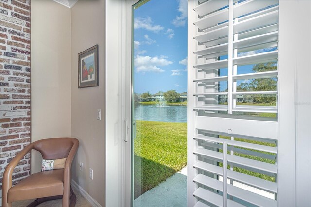 entryway with a water view, brick wall, and baseboards