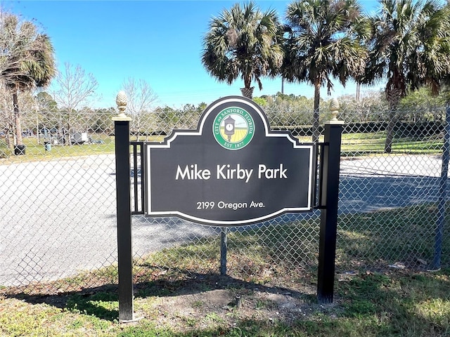 community / neighborhood sign featuring fence