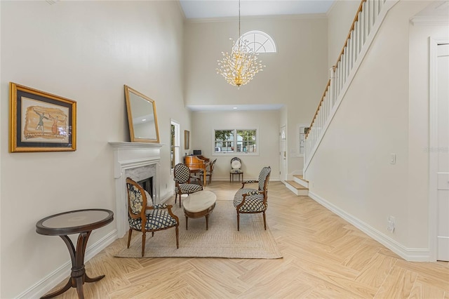 living area with crown molding, an inviting chandelier, a fireplace, light parquet floors, and a high ceiling