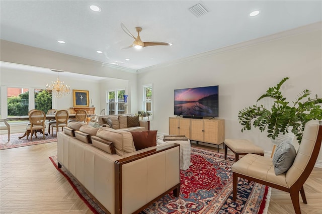 living room with ceiling fan with notable chandelier, ornamental molding, and light parquet flooring