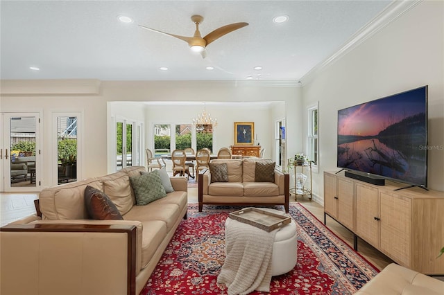 living room with crown molding and ceiling fan with notable chandelier