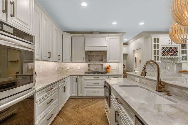 kitchen featuring sink, white cabinetry, stainless steel appliances, decorative light fixtures, and light parquet flooring