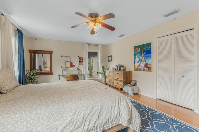 bedroom featuring ceiling fan, wood-type flooring, and a closet