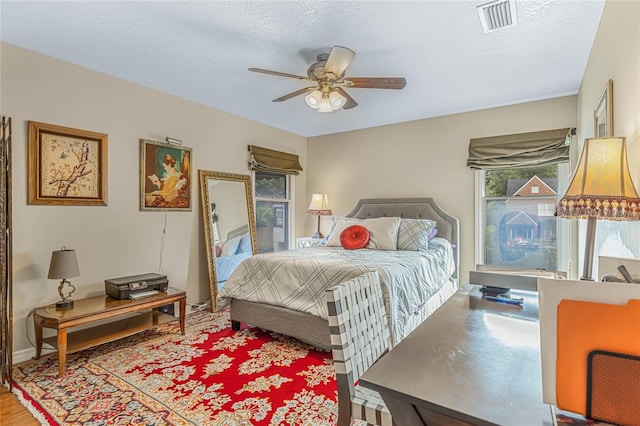 bedroom with ceiling fan and a textured ceiling