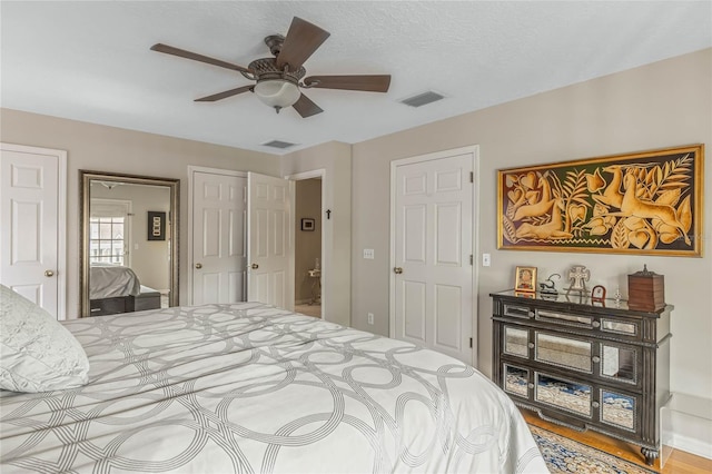 bedroom with ceiling fan and two closets