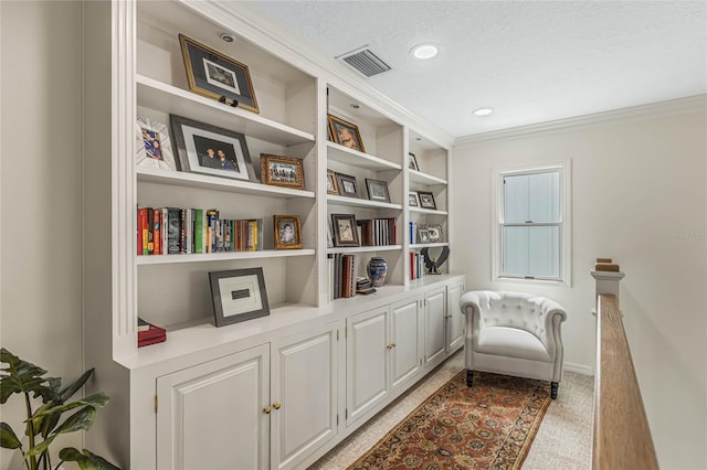 sitting room featuring ornamental molding and a textured ceiling