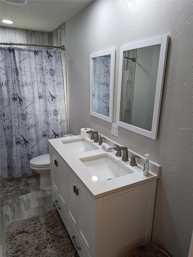 bathroom with vanity, curtained shower, and toilet