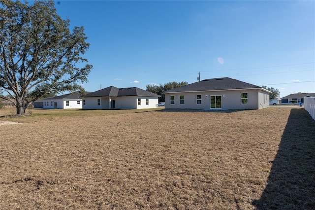 rear view of house featuring a yard
