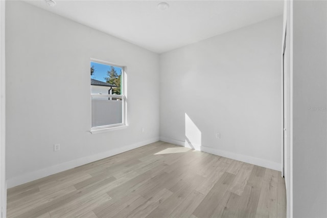 unfurnished room with baseboards and light wood-style flooring