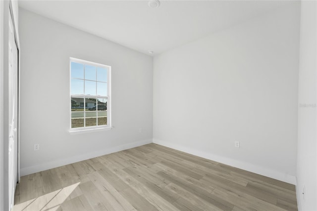 unfurnished room featuring baseboards and light wood-style floors