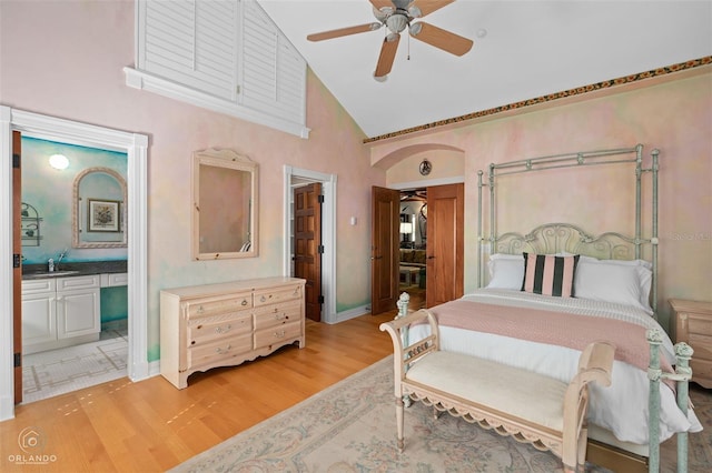 bedroom featuring sink, ensuite bath, ceiling fan, high vaulted ceiling, and light hardwood / wood-style floors