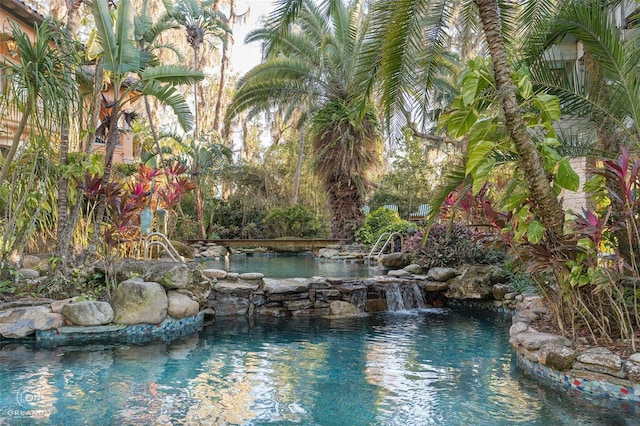 view of swimming pool featuring a small pond