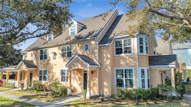 view of front of property featuring roof with shingles and stucco siding