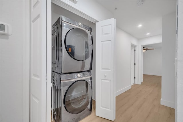 laundry area featuring baseboards, light wood-type flooring, laundry area, recessed lighting, and stacked washer / drying machine