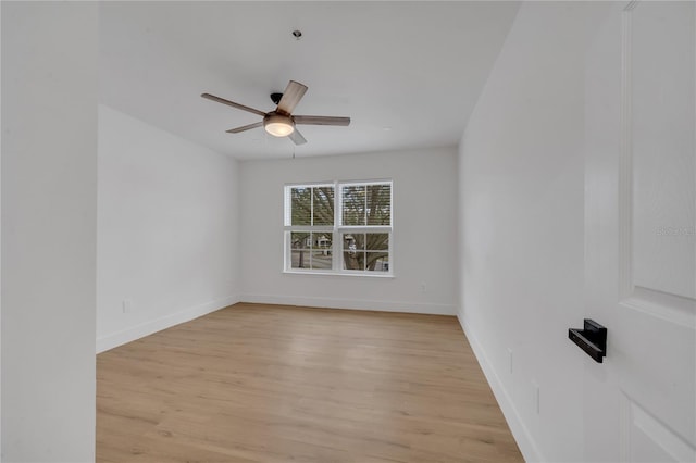 empty room with baseboards, light wood-style flooring, and a ceiling fan