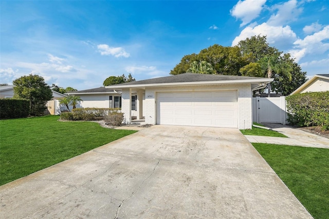 ranch-style home featuring brick siding, an attached garage, a gate, driveway, and a front lawn