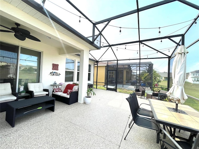 view of patio with ceiling fan, an outdoor hangout area, and glass enclosure