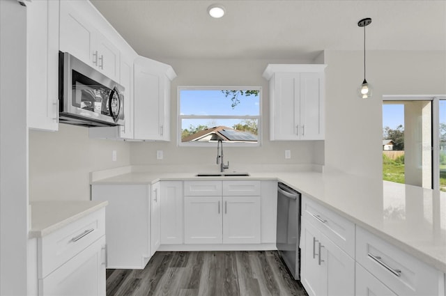 kitchen with white cabinets, plenty of natural light, stainless steel appliances, and sink