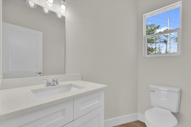 bathroom with hardwood / wood-style flooring, vanity, and toilet