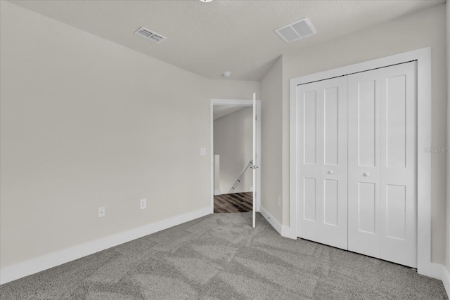 unfurnished bedroom featuring a closet and light colored carpet