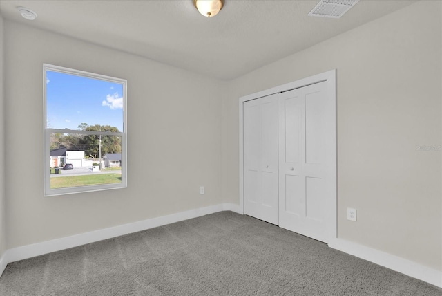 unfurnished bedroom featuring carpet floors and a closet