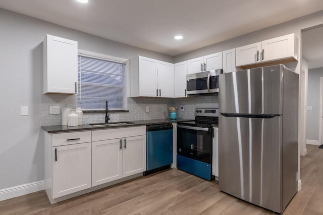 kitchen featuring light wood-type flooring, appliances with stainless steel finishes, sink, and white cabinets