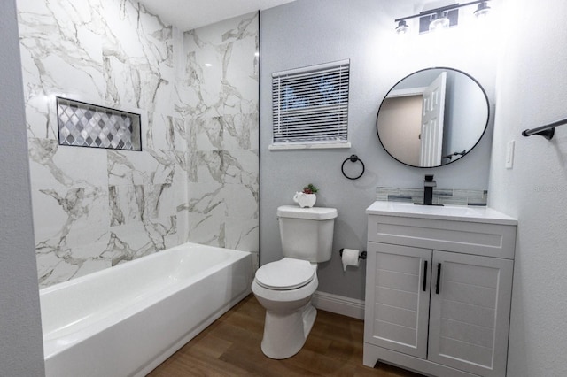 full bathroom featuring hardwood / wood-style flooring, vanity, tiled shower / bath combo, and toilet