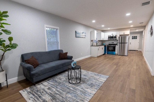 living room featuring sink and light wood-type flooring