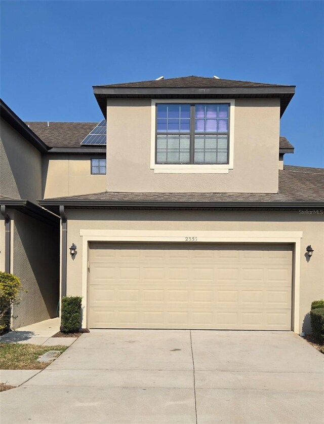 view of front of house with a garage and solar panels