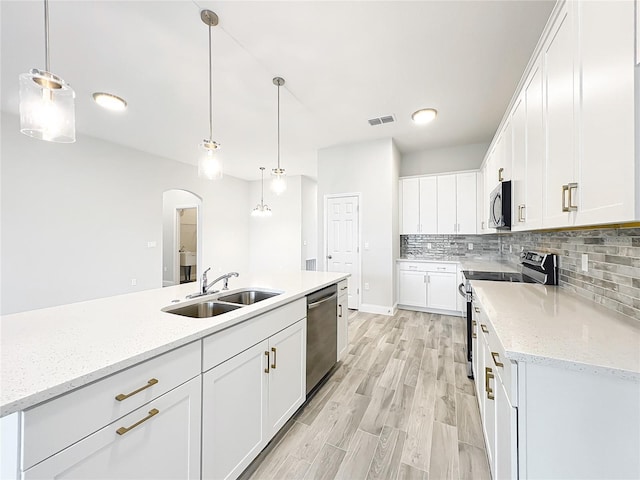 kitchen featuring appliances with stainless steel finishes, sink, pendant lighting, and white cabinets