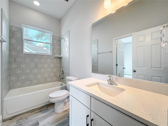 full bathroom featuring tiled shower / bath, vanity, toilet, and wood-type flooring