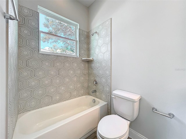 bathroom with toilet and tiled shower / bath combo