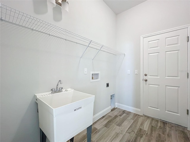 laundry area with sink, ceiling fan, electric dryer hookup, hookup for a washing machine, and light wood-type flooring