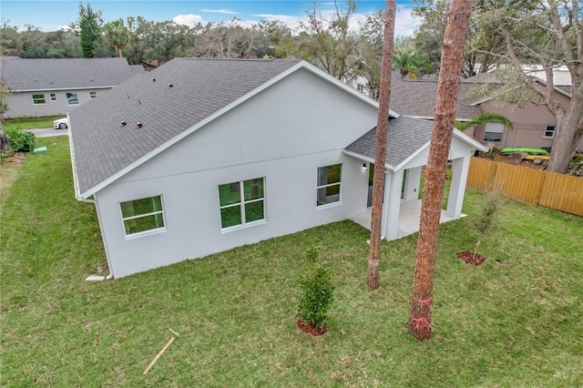 rear view of property featuring a yard and a patio