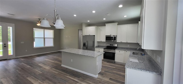 kitchen featuring appliances with stainless steel finishes, light stone countertops, sink, and a kitchen island