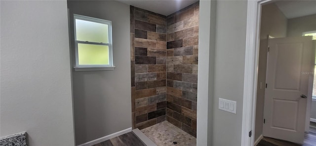 bathroom featuring a tile shower and hardwood / wood-style flooring