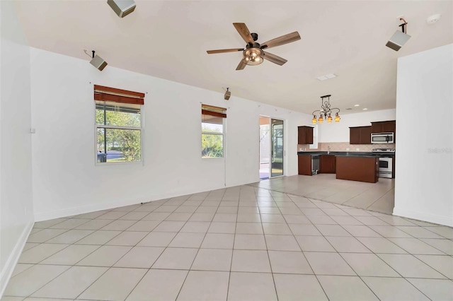 unfurnished living room featuring ceiling fan with notable chandelier and light tile patterned floors