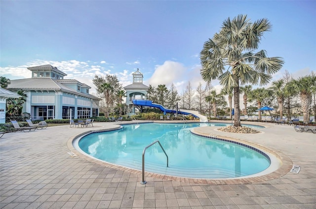 view of pool featuring a water slide and a patio area