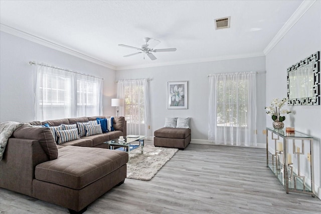 living room with crown molding, light hardwood / wood-style floors, and ceiling fan