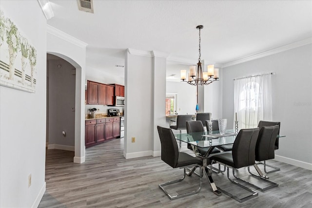 dining area featuring wood-type flooring, plenty of natural light, and crown molding