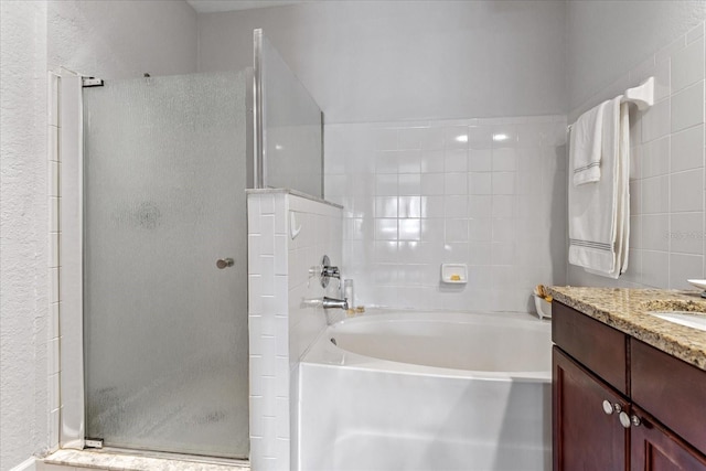 bathroom with vanity and shower with separate bathtub