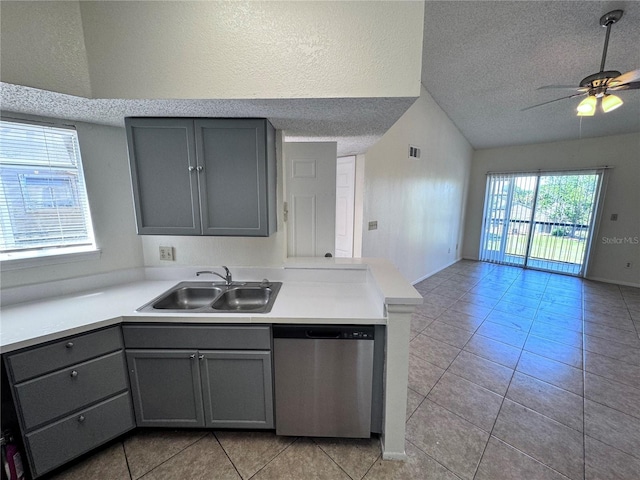 kitchen with sink, gray cabinets, dishwasher, a textured ceiling, and kitchen peninsula