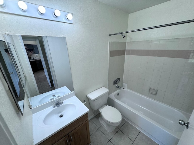 full bathroom featuring vanity, tile patterned floors, toilet, and tiled shower / bath