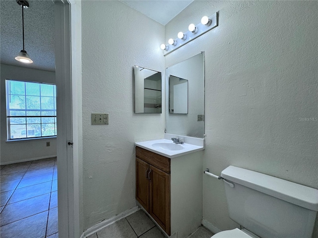 bathroom with vanity, a textured ceiling, tile patterned floors, and toilet