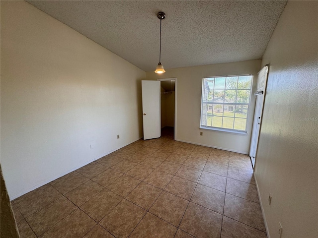 unfurnished dining area with vaulted ceiling, tile patterned floors, and a textured ceiling