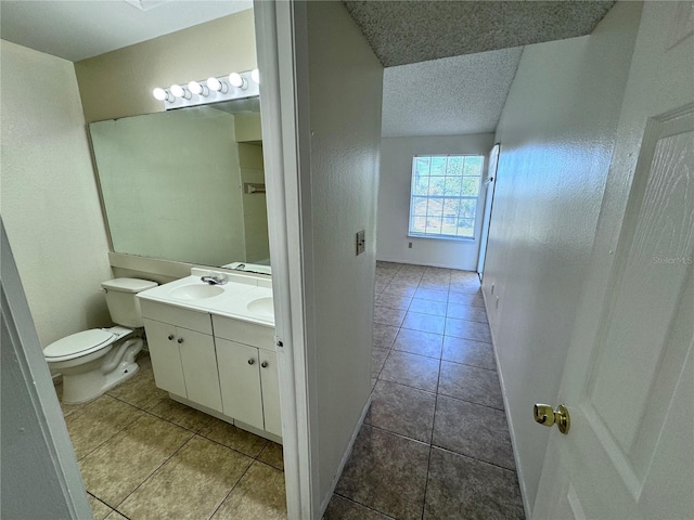 bathroom with vanity, a textured ceiling, tile patterned floors, and toilet