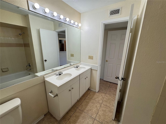 full bathroom with vanity, tile patterned flooring, tiled shower / bath combo, and toilet