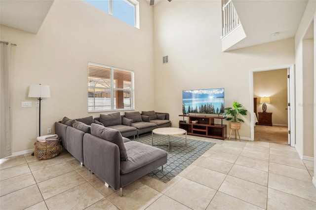 living room featuring a healthy amount of sunlight, a high ceiling, and light tile patterned floors