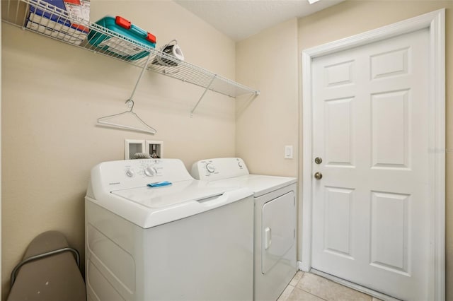 washroom with light tile patterned floors and washer and dryer