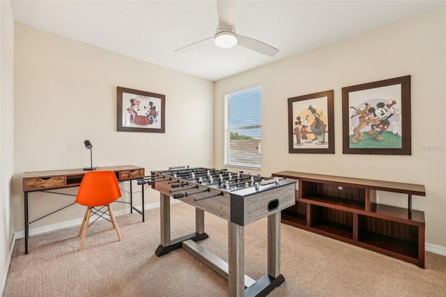 recreation room with ceiling fan and light colored carpet